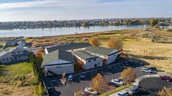 An aerial view of a house with a lake in the background